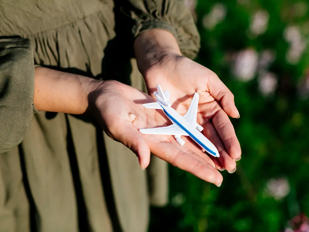 Ein Modellflugzeug vor einem grünen Naturhintergrund als Symbol für nachhaltige Luftfahrt.