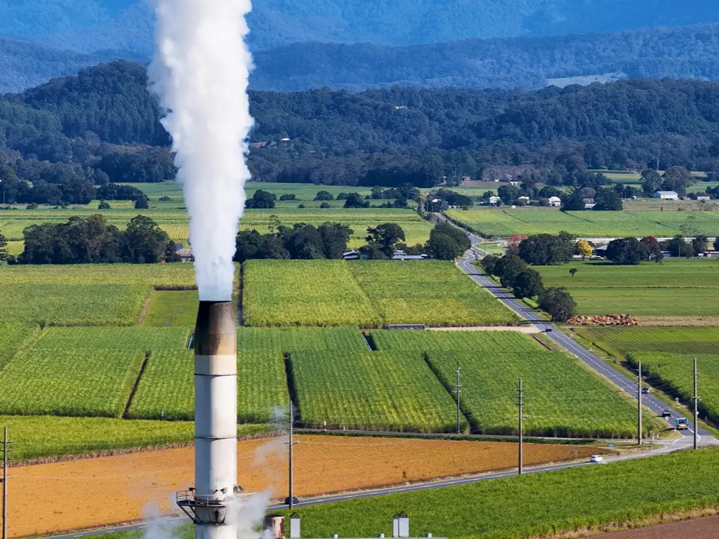 Paisagem agrícola em redor de uma instalação industrial de processamento de biomassa.